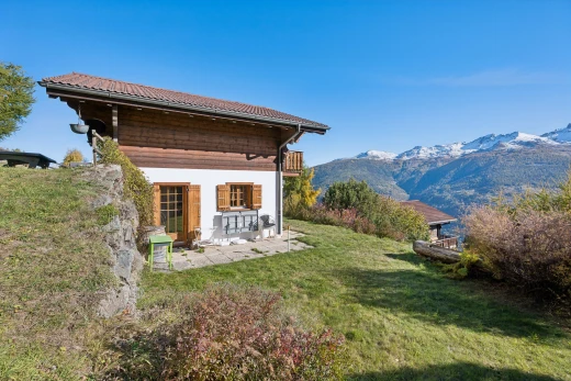 view of property featuring a yard, a mountain view, a patio, and a balcony