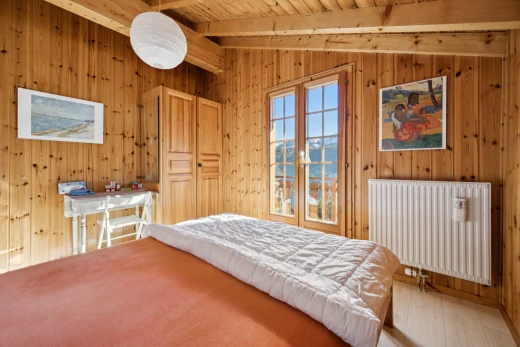 room with radiator heating unit, light wood-style floors, wooden ceiling, wood walls, and vaulted ceiling with beams
