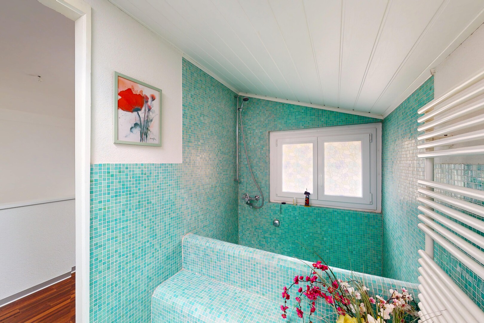 salle de bains avec plafond voûté, radiateur, lumière naturelle, mur en carrelage, et sol en finition bois