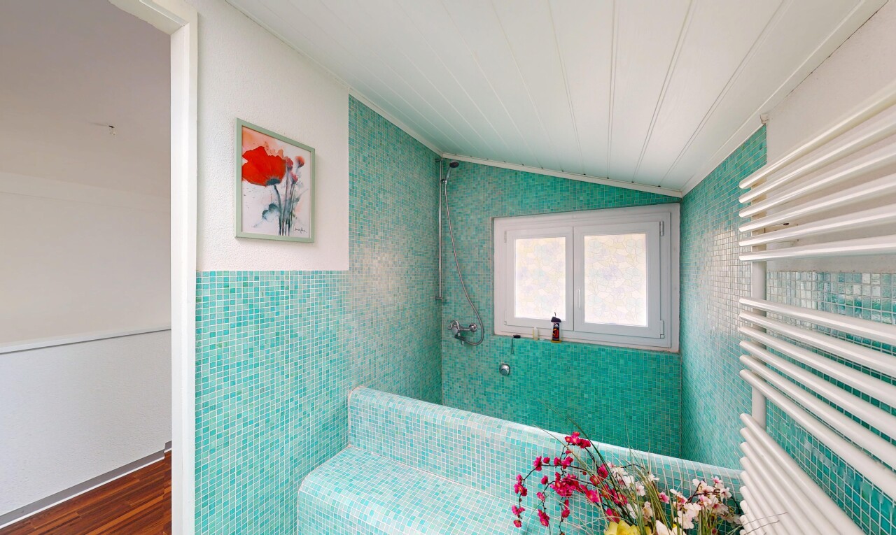 salle de bains avec plafond voûté, radiateur, lumière naturelle, mur en carrelage, et sol en finition bois