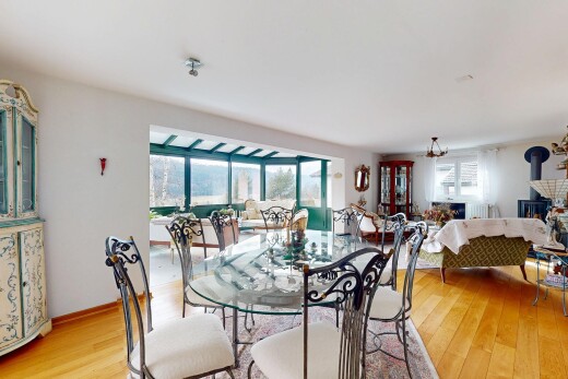 salon / salle à manger avec cloison sèche, lumière naturelle, poêle à bois, et sol en finition bois