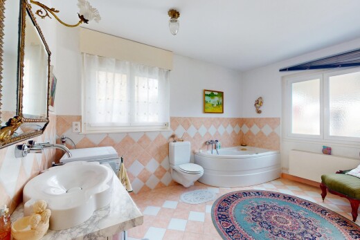 salle de bains avec évier, lumière naturelle, mur en carrelage, et bain