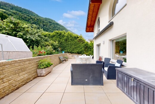 terrace featuring outdoor dining space, a mountain view, and a view of trees
