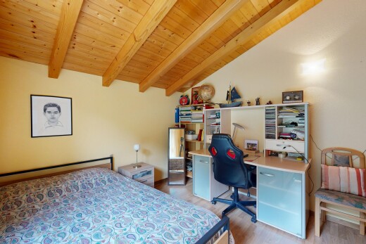 zimmer / schlafzimmer mit inside property, vaulted ceiling, dachschräge, wood finish floor, und holzfußboden