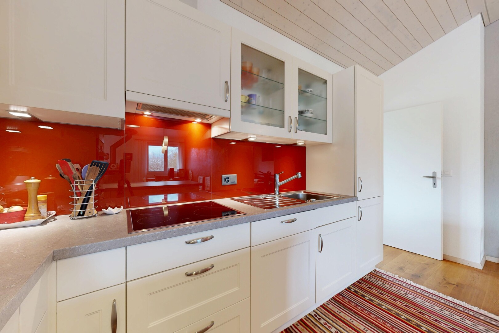 cuisine avec armoires blanches, white cabinets, hotte, plafond en bois, et wood ceiling