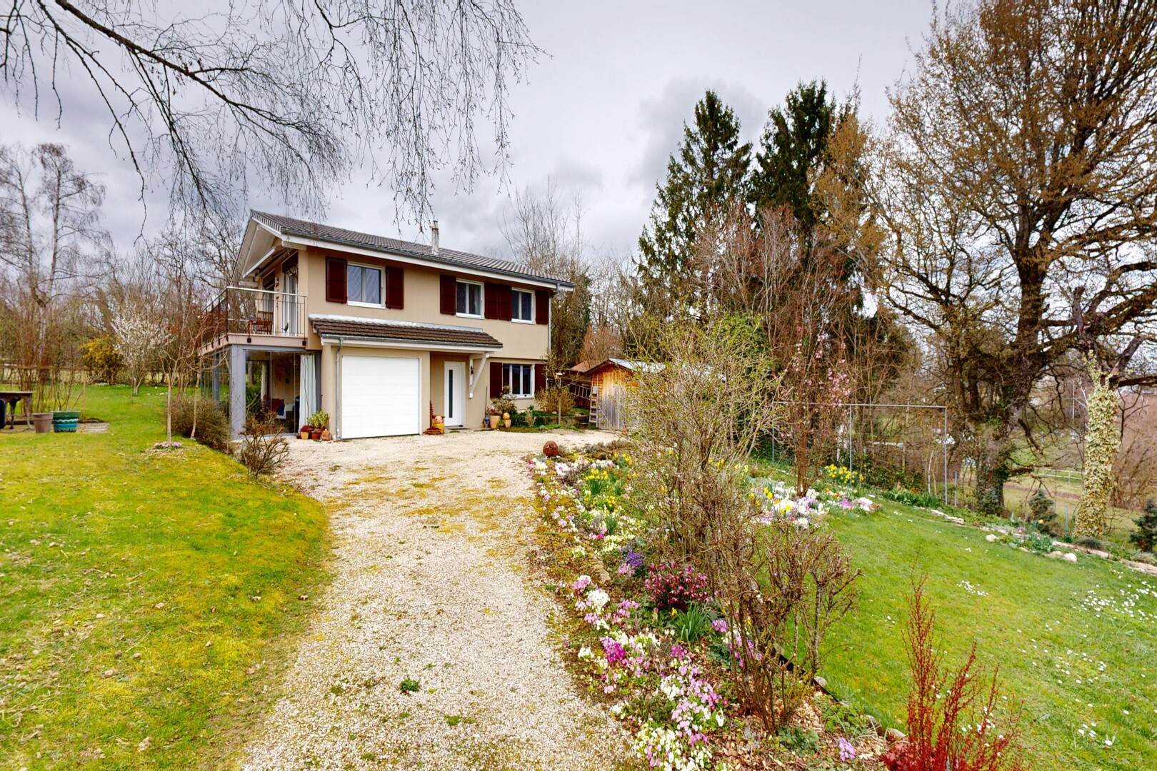 façade avec balcon, pelouse, property visible, allée, et garage intégré