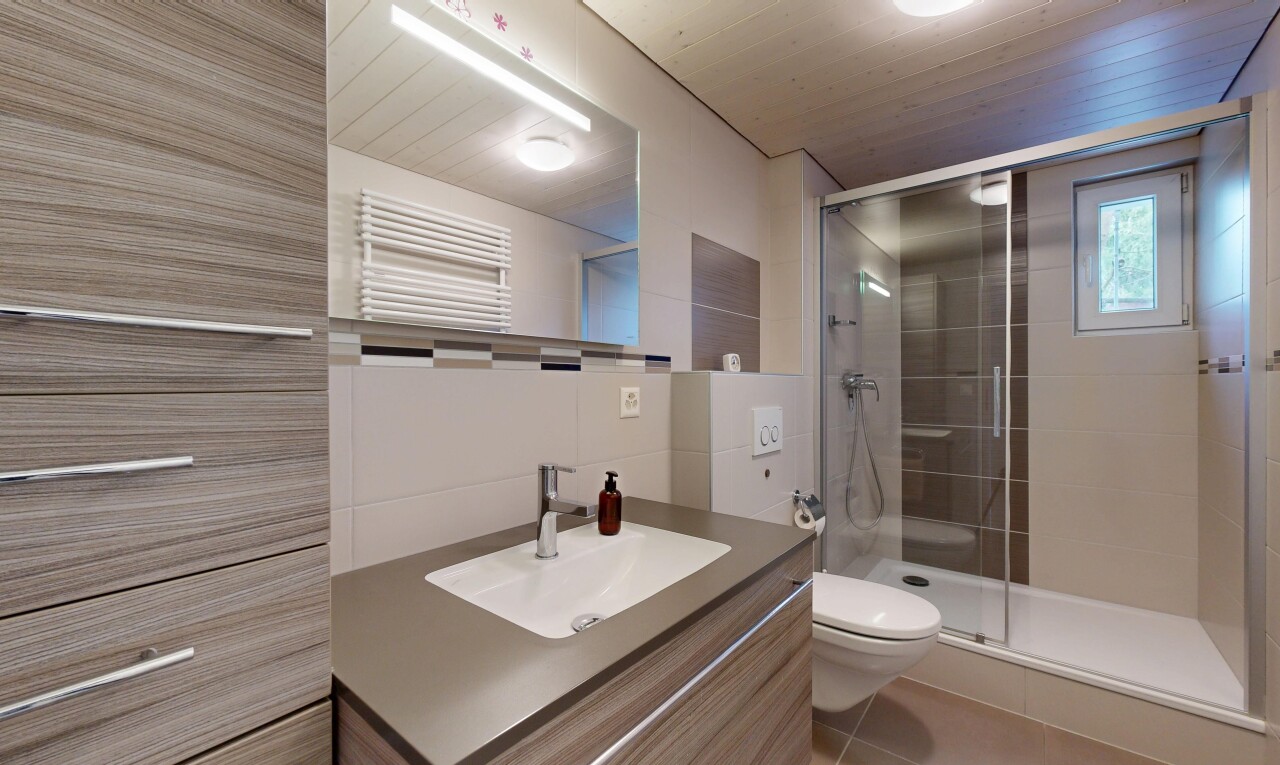 salle de bains avec lavabo (ou coiffeuse selon le contexte), radiateur, douche, salle de bain complète, et inside property
