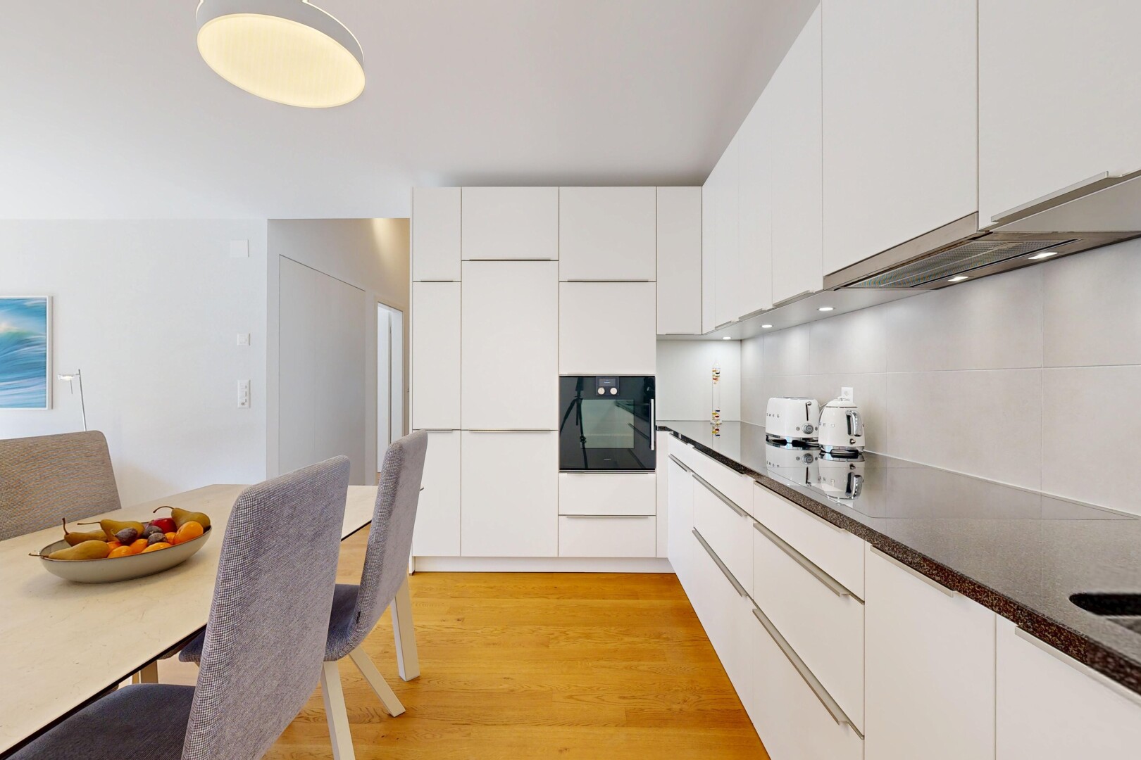 cuisine avec dark countertops, armoires à panneau plat, flat panel cabinets, armoires blanches, et white cabinets