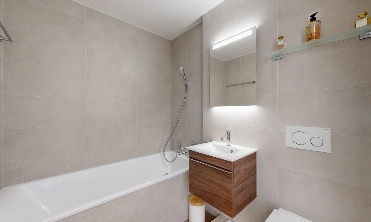 salle de bains avec tile wall, mur en carrelage, miroir, salle de bain complète, et lavabo (ou coiffeuse selon le contexte)