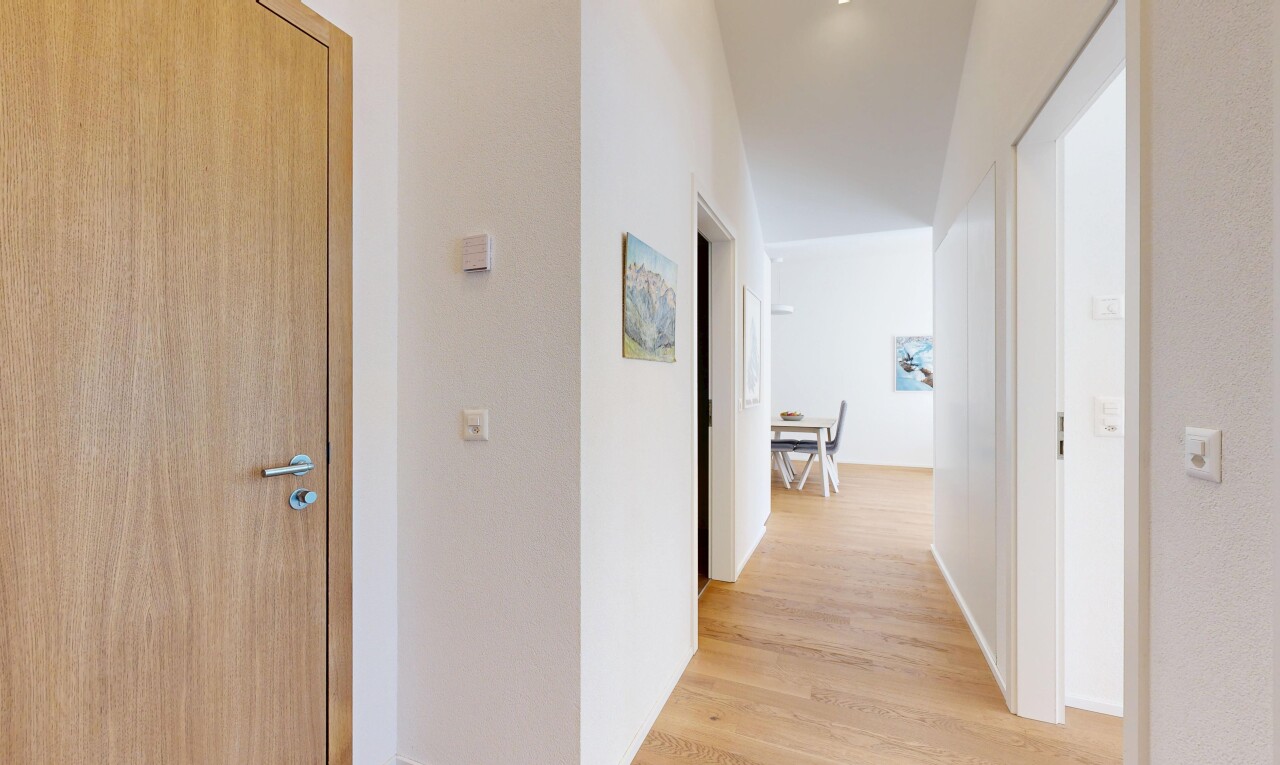 couloir avec sol en finition bois, wood finish floor, inside property, cloison sèche, et drywall