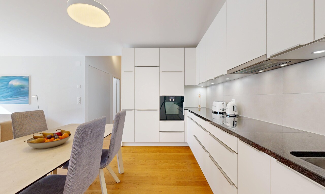 cuisine avec dark countertops, armoires à panneau plat, flat panel cabinets, armoires blanches, et white cabinets