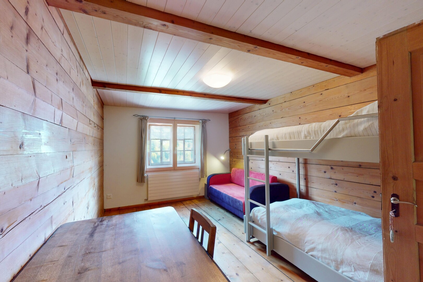 chambre avec plafond en bois, lumière naturelle, plafond à poutres, et mur en bois