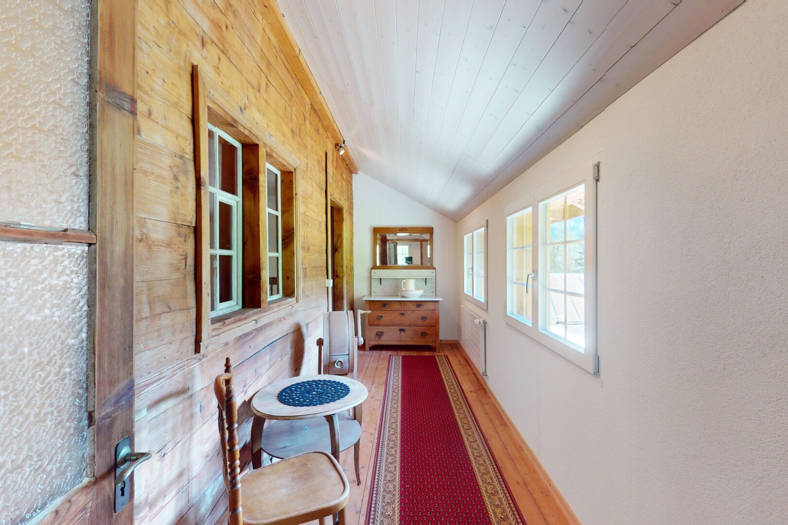 couloir avec plafond voûté, plafond en bois, lumière naturelle, et sol en finition bois