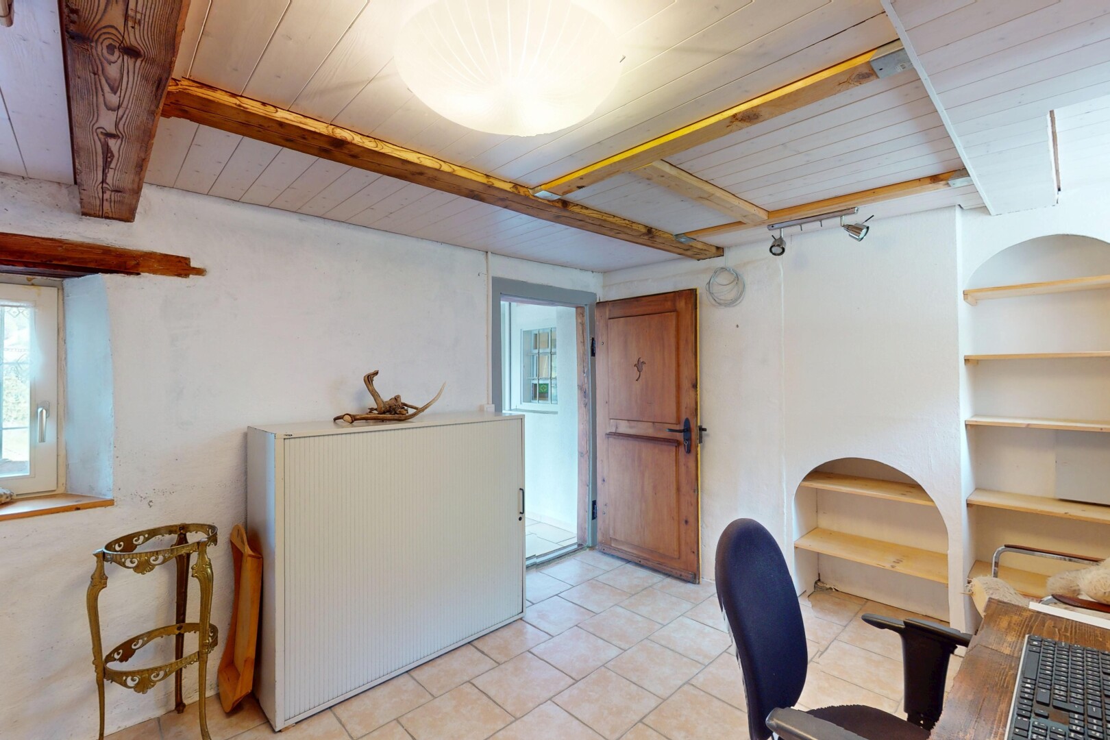 espace intérieur avec lumière naturelle, plafond en bois, sol en carrelage, et plafond à poutres