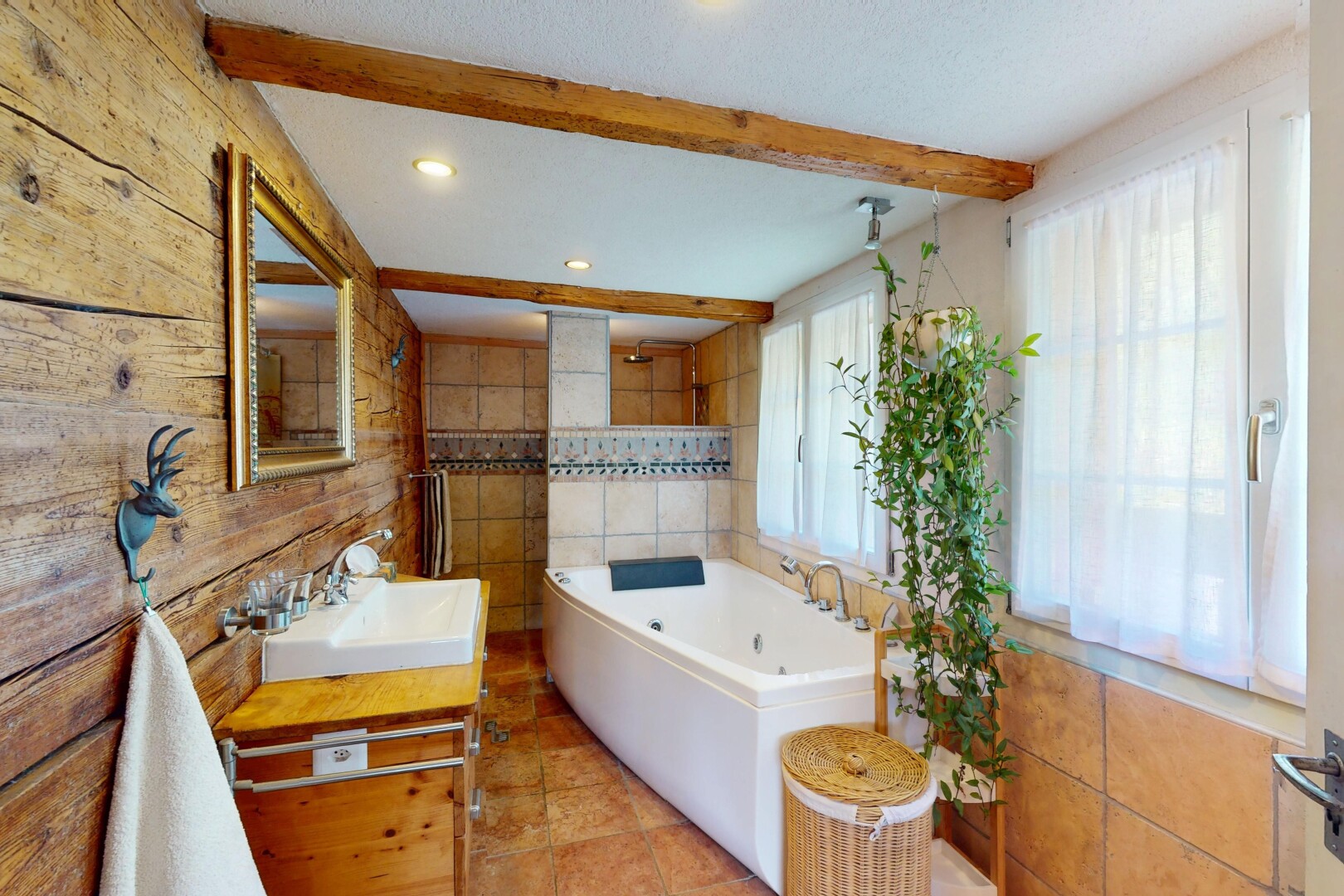 salle de bains avec évier, miroir, lumière naturelle, et plafond à poutres