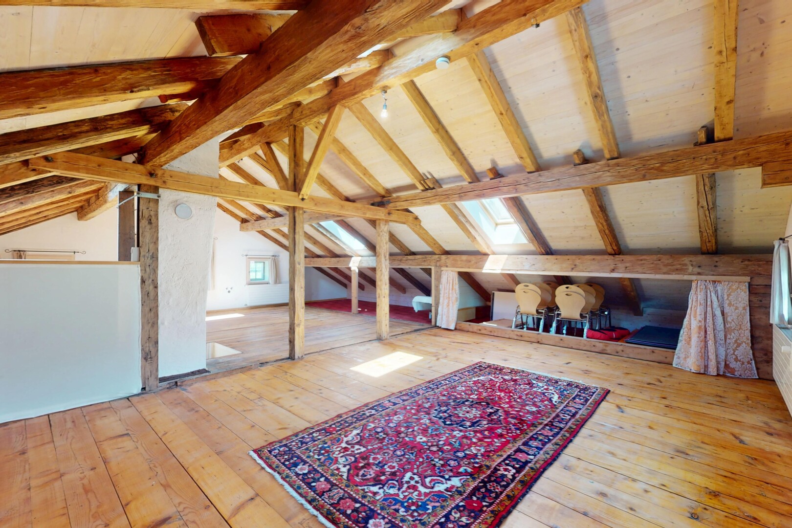 salon avec plafond voûté, plafond à poutres, et sol en finition bois