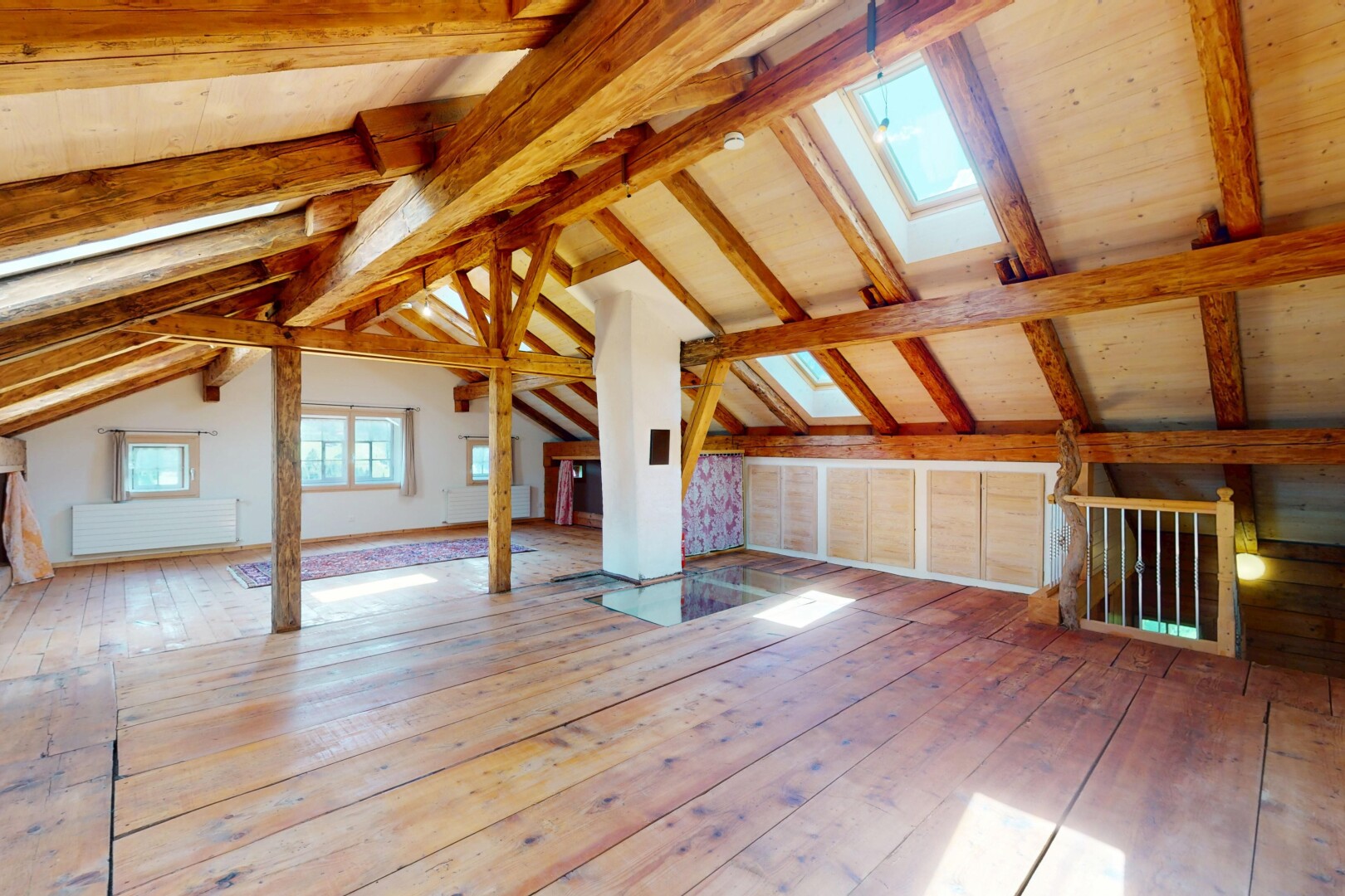 pièce vide avec plafond à poutres, lumière naturelle, plafond voûté, sol en finition bois, et puits de lumière