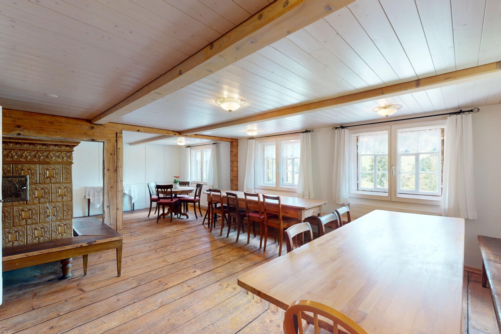 salle à manger avec plafond en bois, lumière naturelle, plafond à poutres, et sol en finition bois