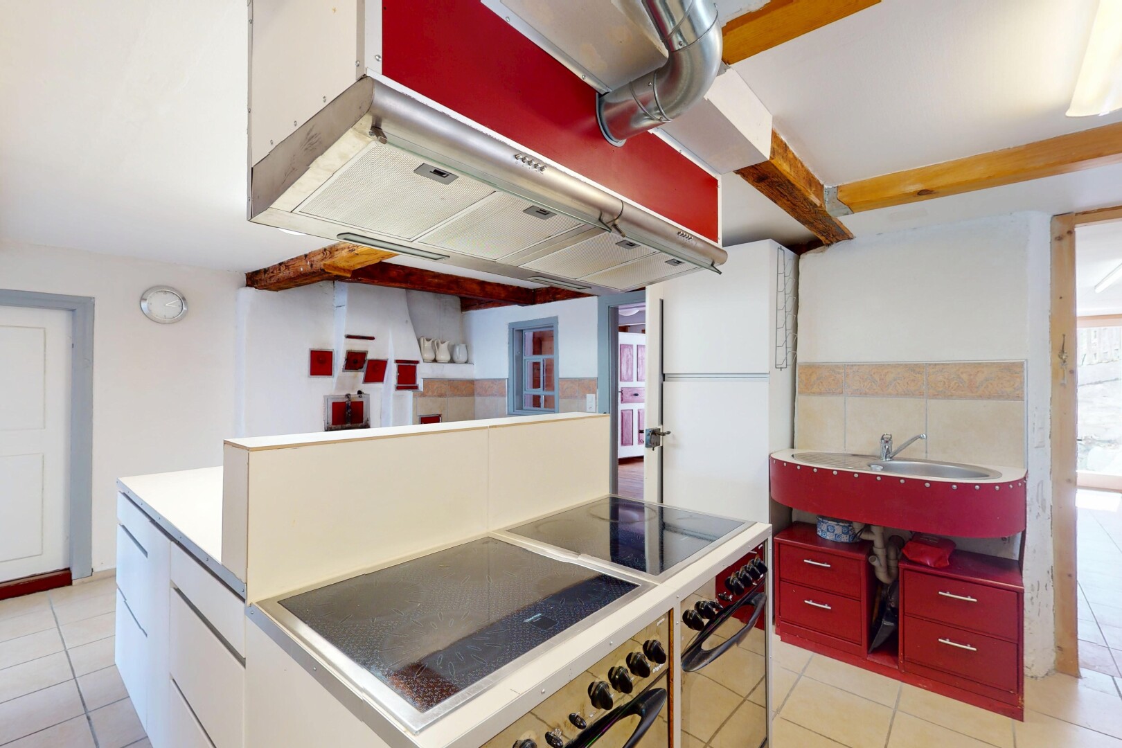 cuisine avec four, évier, lumière naturelle, sol en carrelage, et cloison sèche