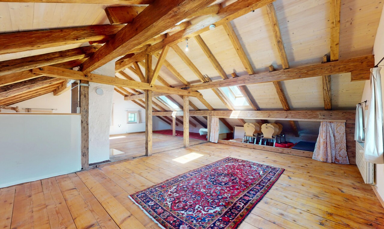 salon avec plafond voûté, plafond à poutres, et sol en finition bois