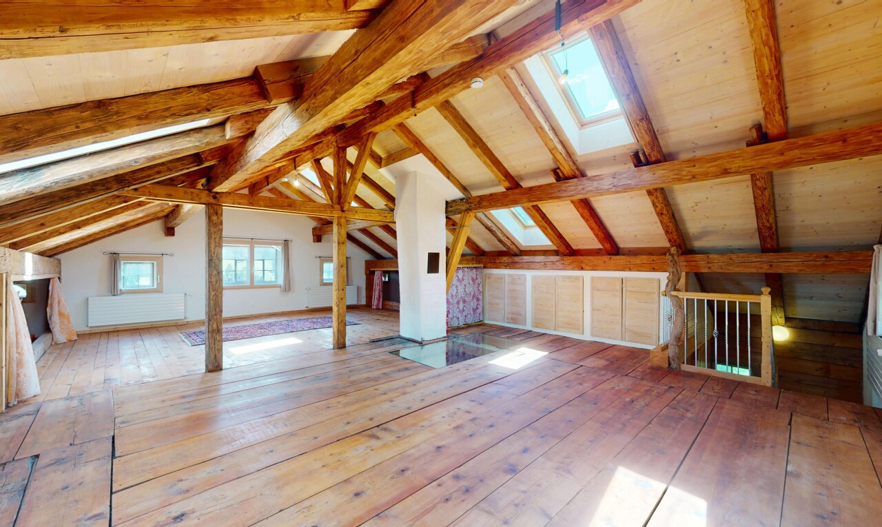 pièce vide avec plafond à poutres, lumière naturelle, plafond voûté, sol en finition bois, et puits de lumière