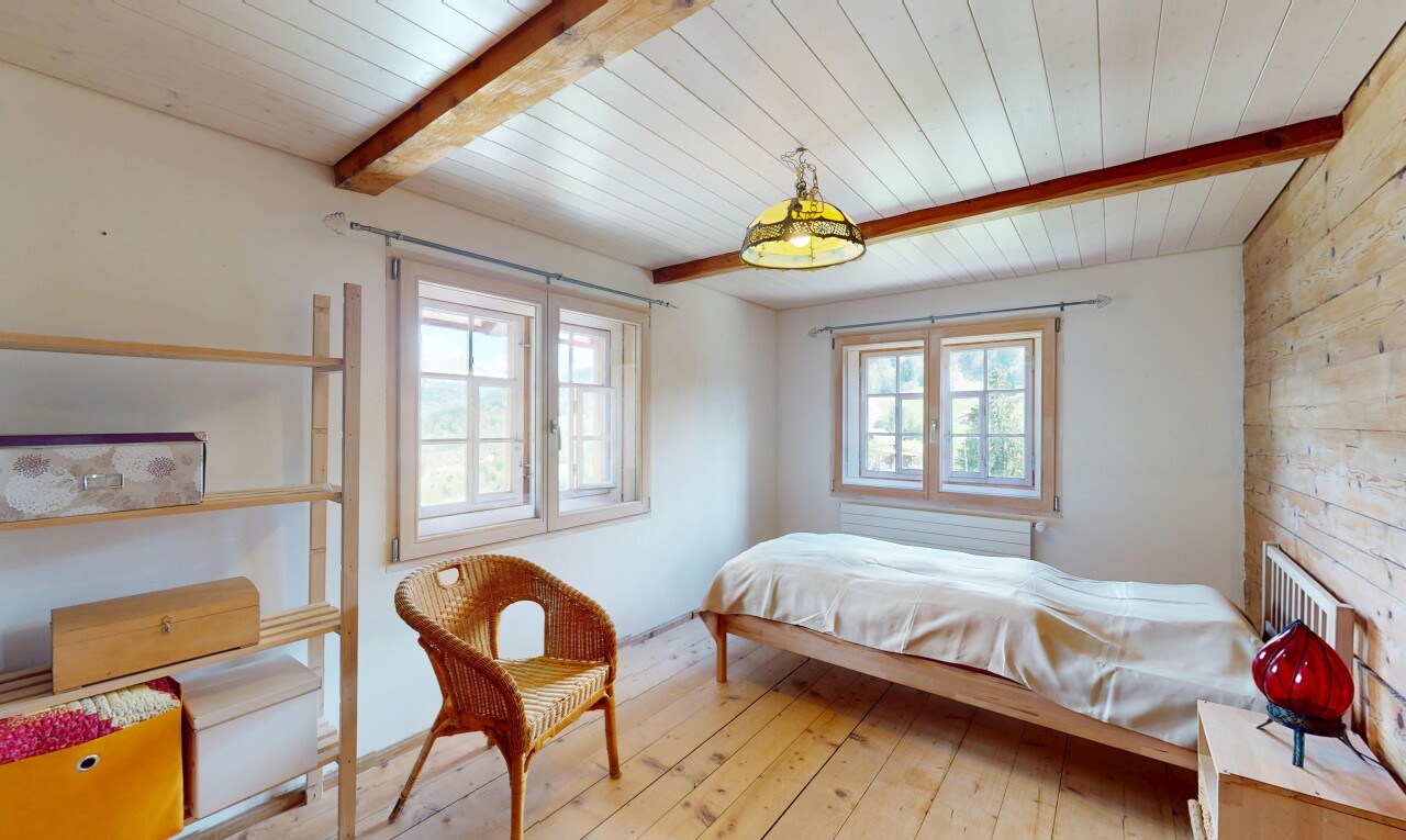 chambre avec plafond en bois, lumière naturelle, plafond à poutres, et sol en finition bois