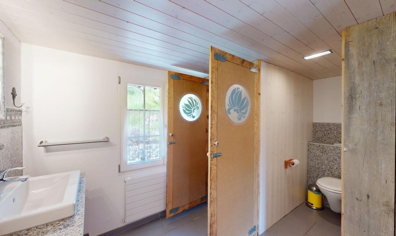 salle de bains avec plafond en bois, évier, radiateur, toilette, et lumière naturelle