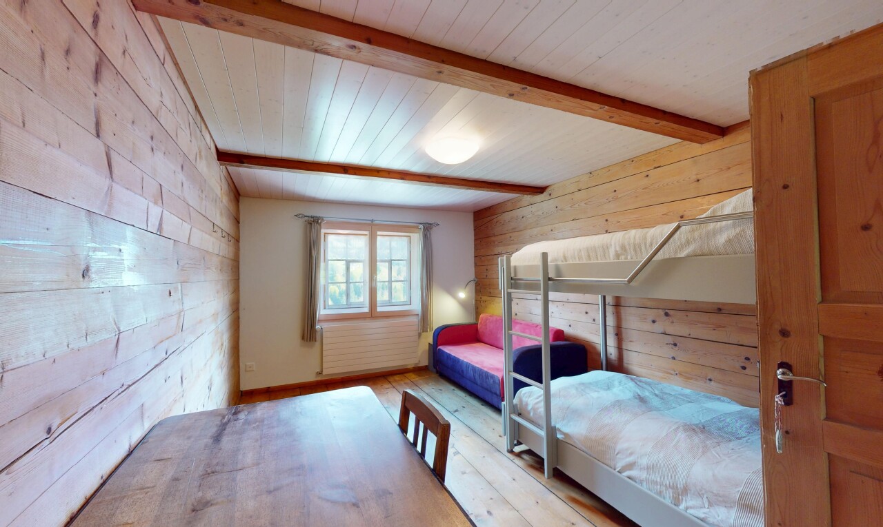 chambre avec plafond en bois, lumière naturelle, plafond à poutres, et mur en bois