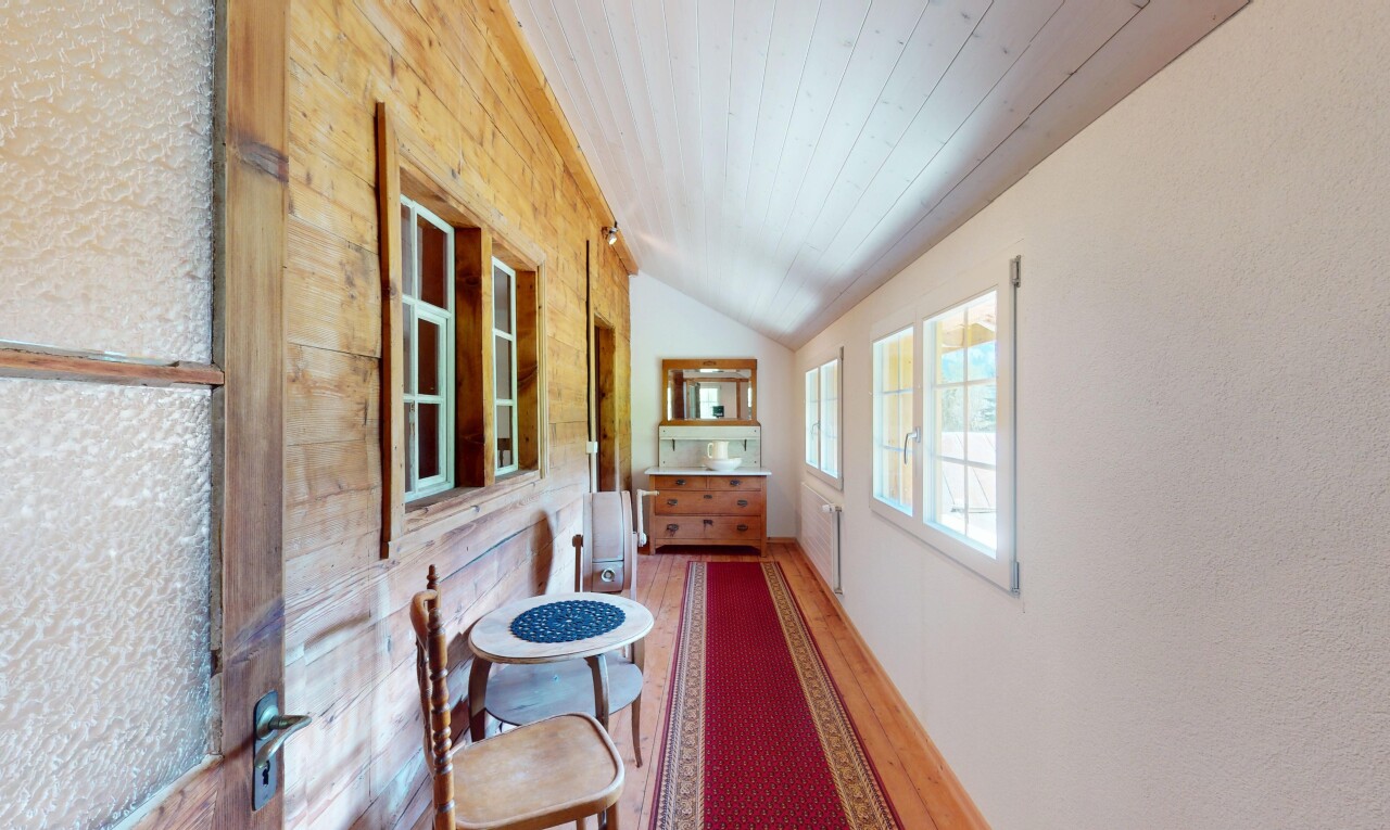 couloir avec plafond voûté, plafond en bois, lumière naturelle, et sol en finition bois