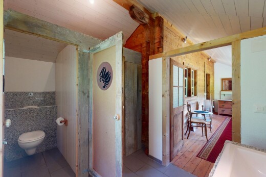 salle de bains avec plafond voûté, plafond en bois, sol en carrelage, et toilette
