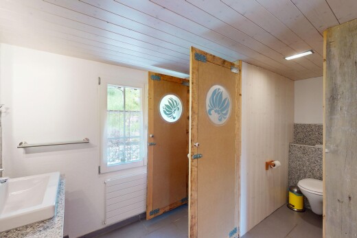 bad mit kühler, natürliches licht, waschbecken, toilette, und holzdecke