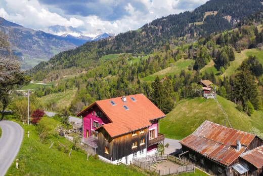 außenansicht mit blick auf die berge, brettverschalung, und vertikale verkleidung