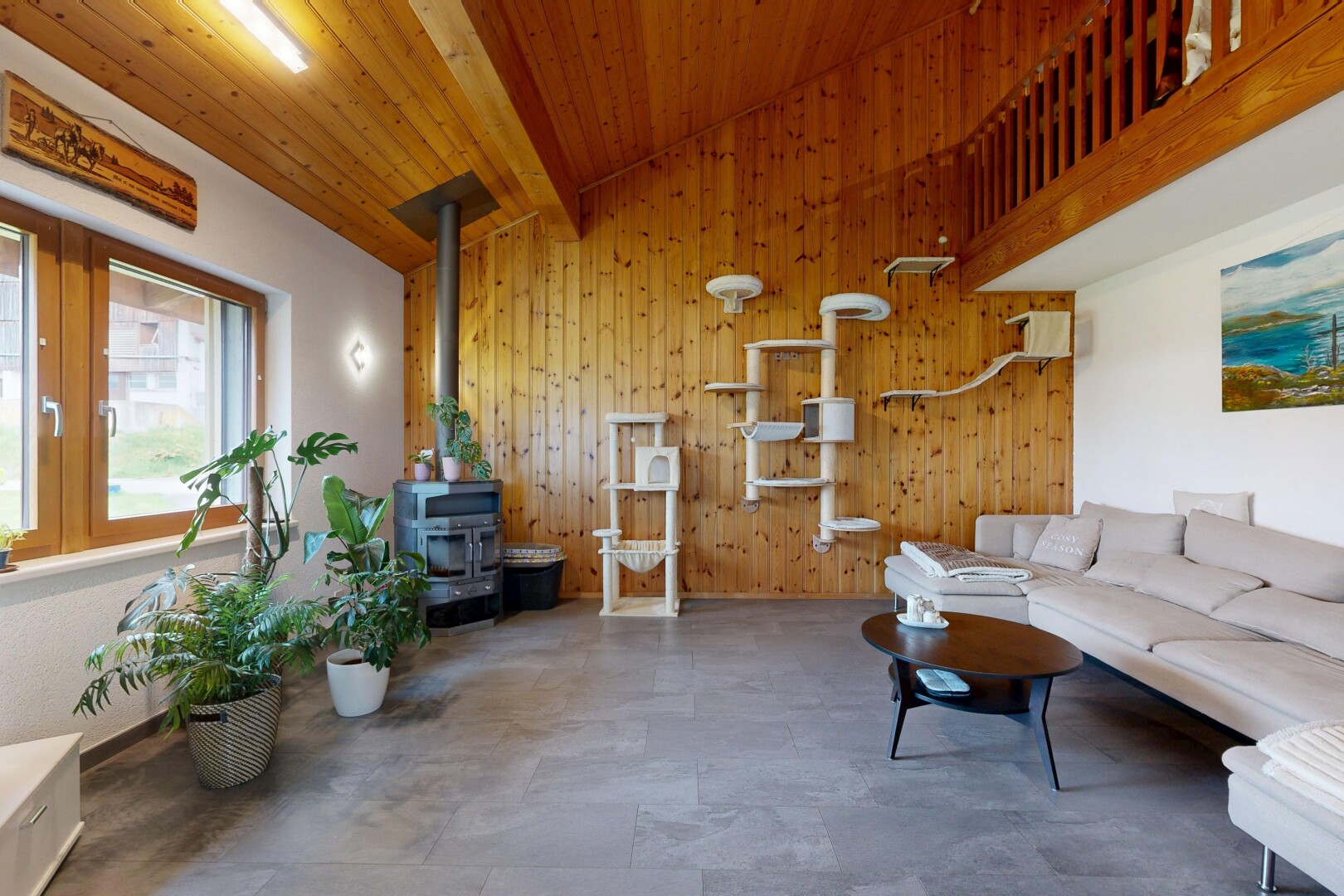 salon avec plafond à poutres, beamed ceiling, lumière naturelle, natural light, et mur en bois