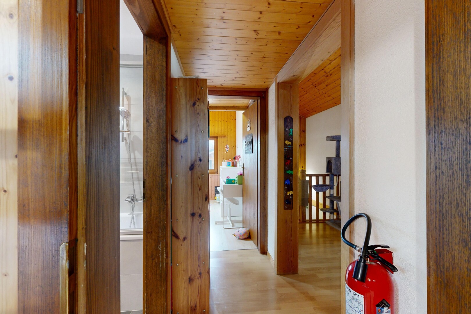 couloir avec plafond en bois, wood ceiling, sol en finition bois, wood finish floor, et inside property