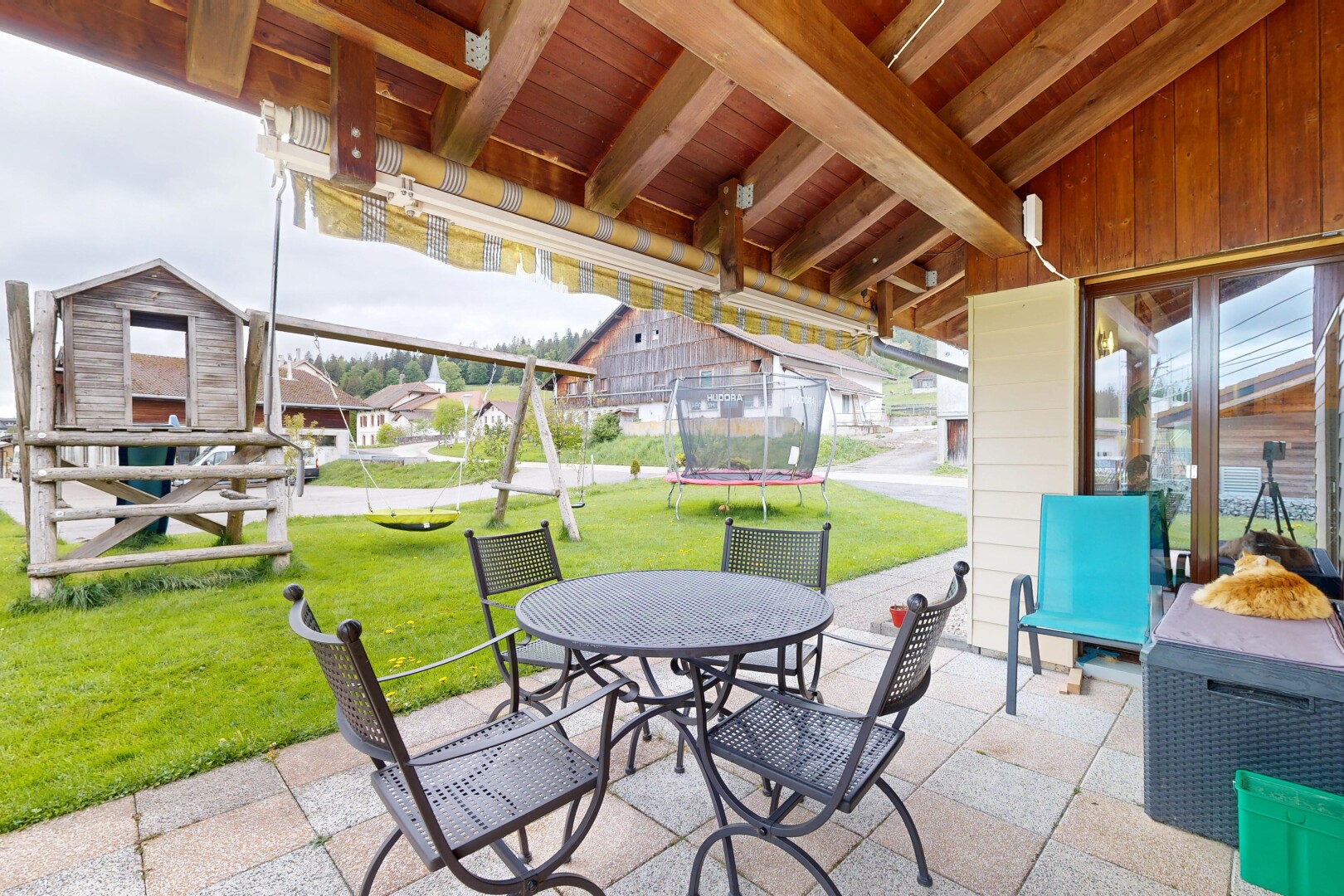 terrasse avec coin repas extérieur, trampoline, terrasse, pelouse, et overcast