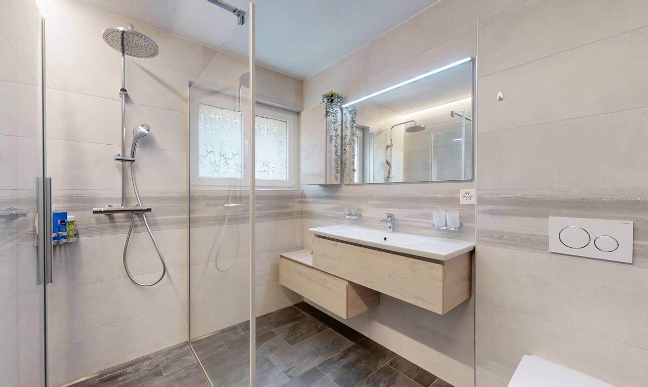 salle de bains avec salle de bain complète, douche, lavabo (ou coiffeuse selon le contexte), tile wall, et mur en carrelage