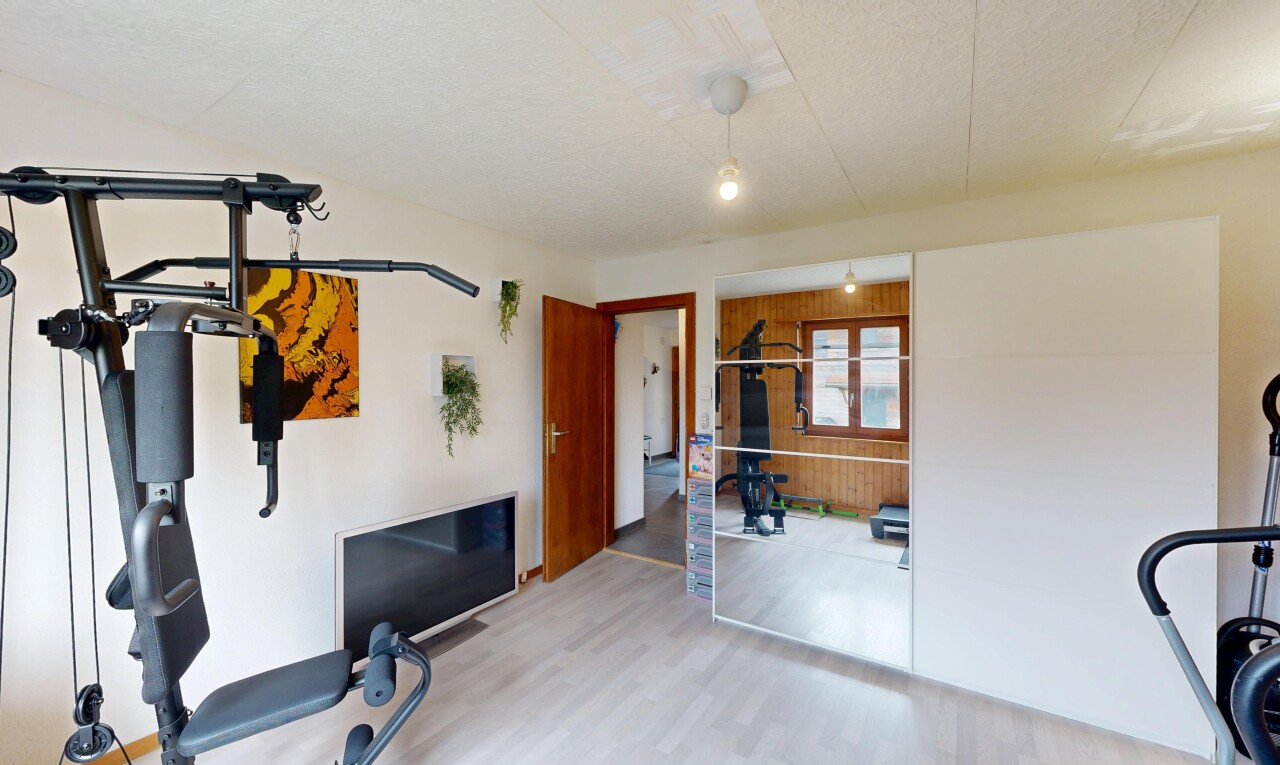 gym avec inside property, drywall, cloison sèche, wood finish floor, et sol en finition bois