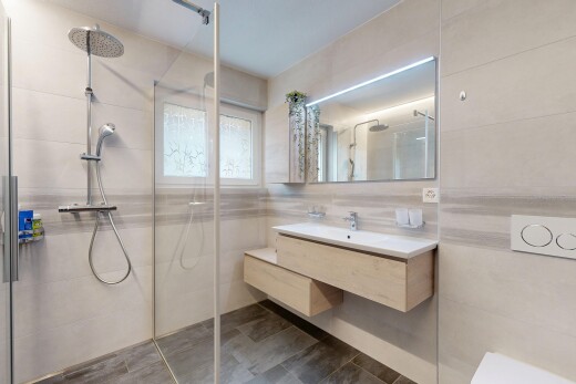 salle de bains avec salle de bain complète, douche, lavabo (ou coiffeuse selon le contexte), tile wall, et mur en carrelage
