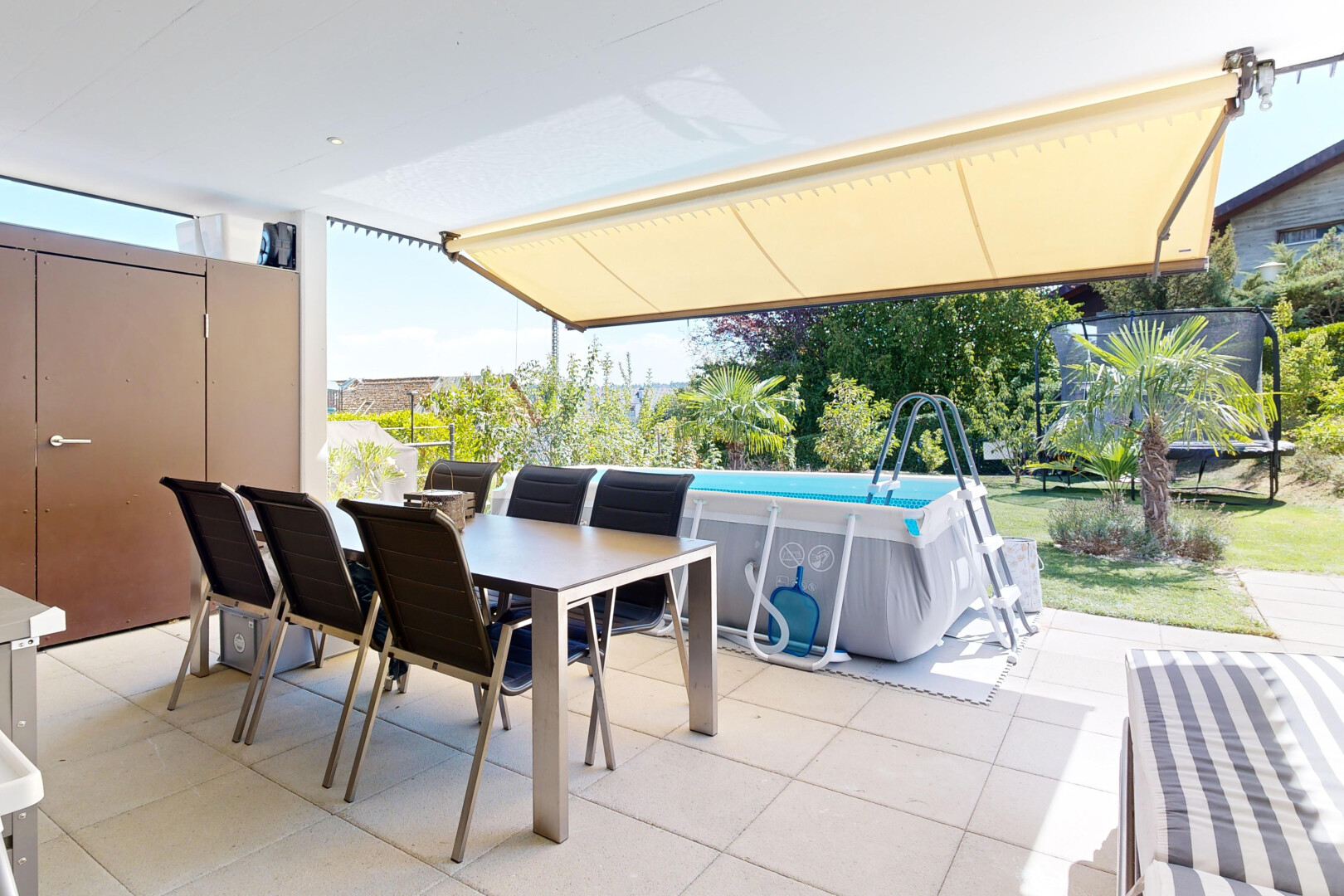 terrasse avec rampe, coin repas extérieur, piscine, et day time