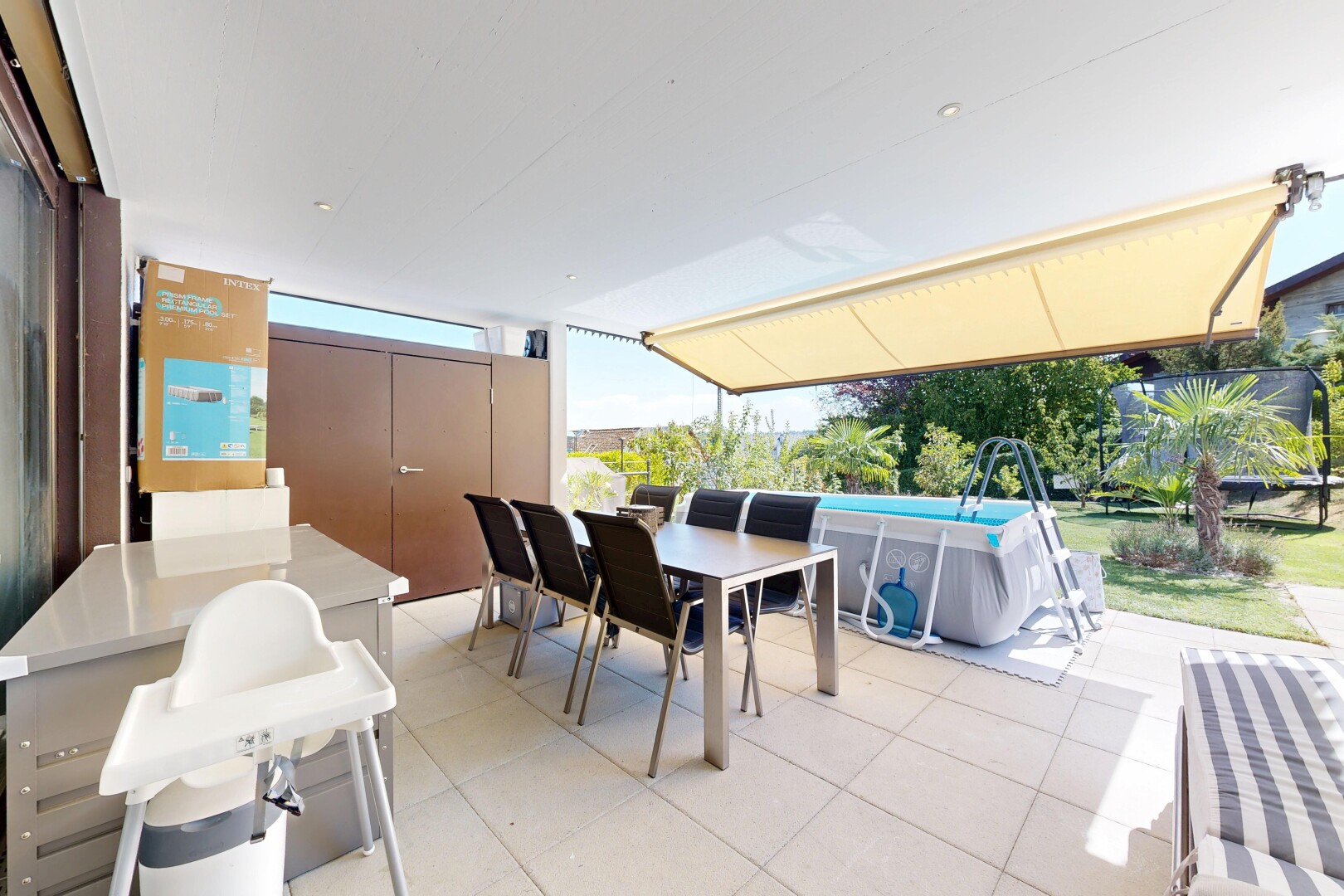 terrasse avec coin repas extérieur, rampe, et piscine