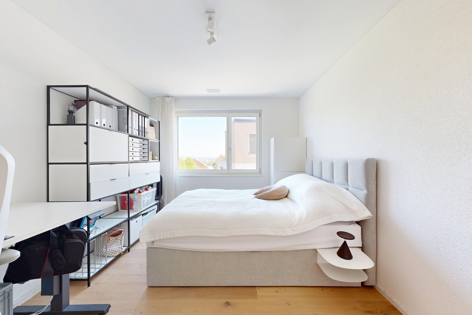 chambre avec sol en finition bois, wood finish floor, lumière naturelle, inside property, et espace bureau