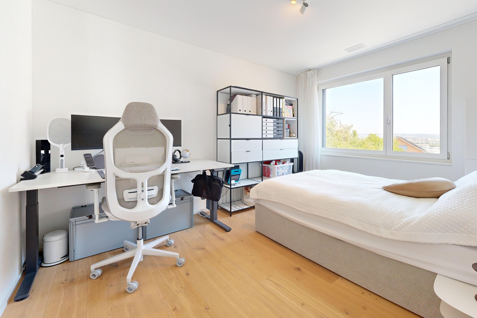 chambre avec espace bureau, cloison sèche, drywall, sol en finition bois, et wood finish floor