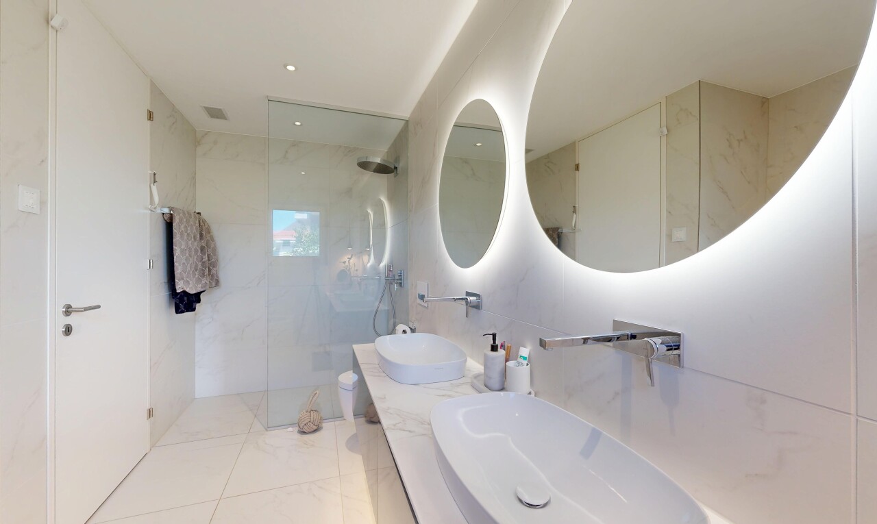 salle de bains avec salle de bain complète, miroir, douche, double vasque, et light floor