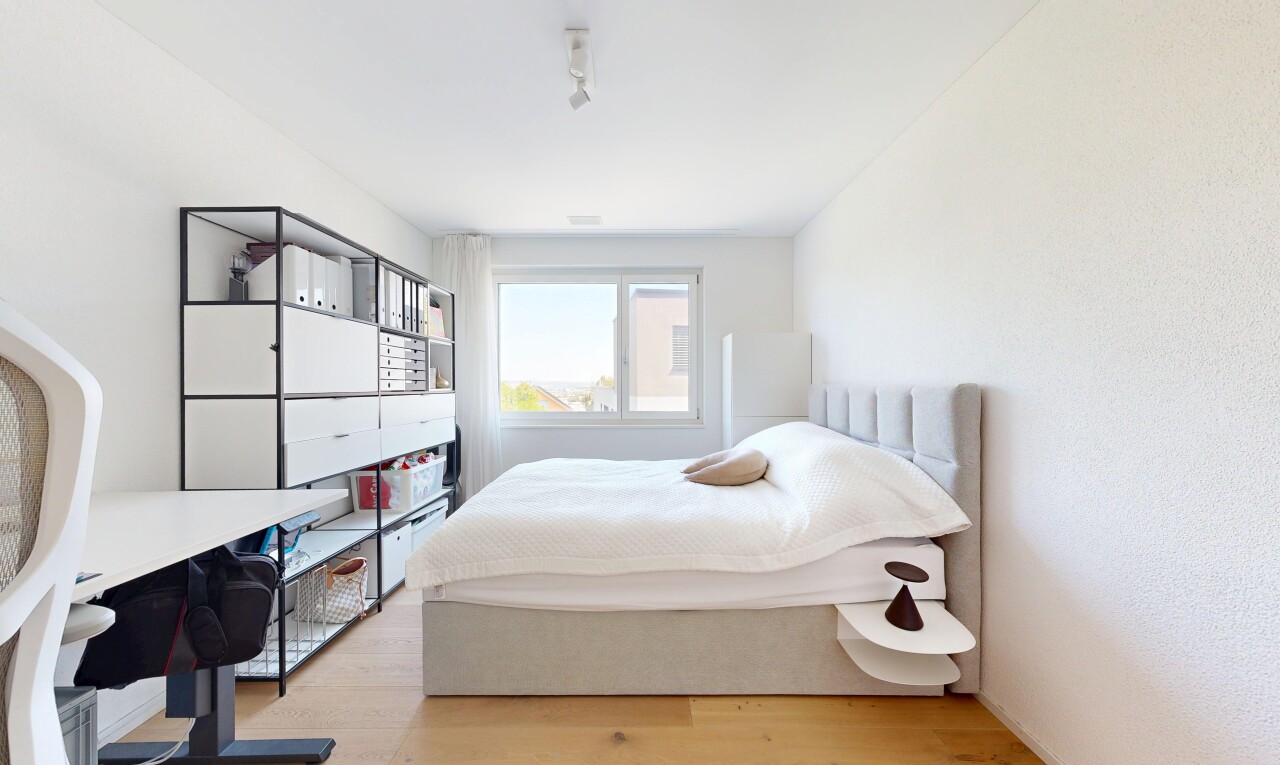 chambre avec sol en finition bois, wood finish floor, lumière naturelle, inside property, et espace bureau