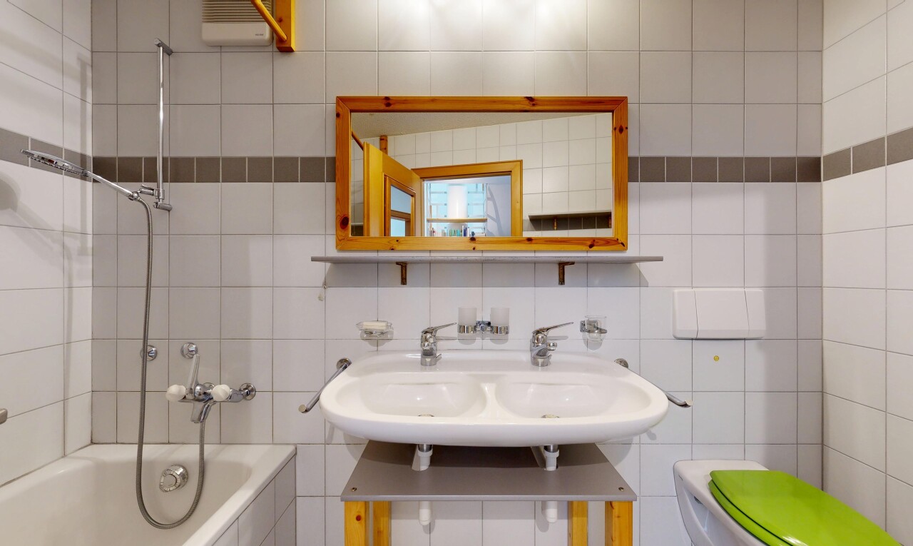 bad mit tile wall, fliesenwand, spiegel, waschbecken, und kombiniertes bad / dusche