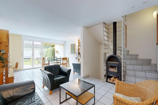 wohnzimmer mit holzofen, gipskartonwand, drywall, treppen, und fliesenboden