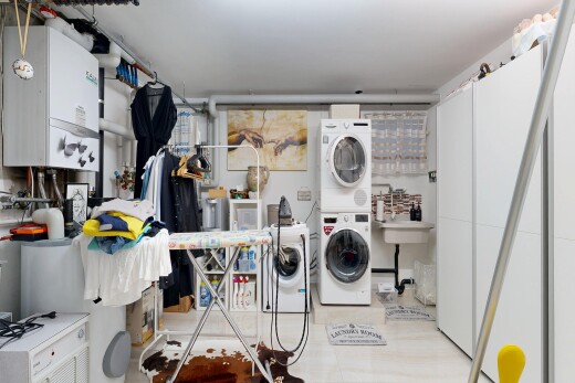 buanderie avec light floor, inside property, lave-linge et sèche-linge superposés, et chauffe-eau