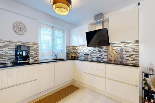 cuisine avec dark countertops, armoires à panneau plat, flat panel cabinets, armoires blanches, et white cabinets