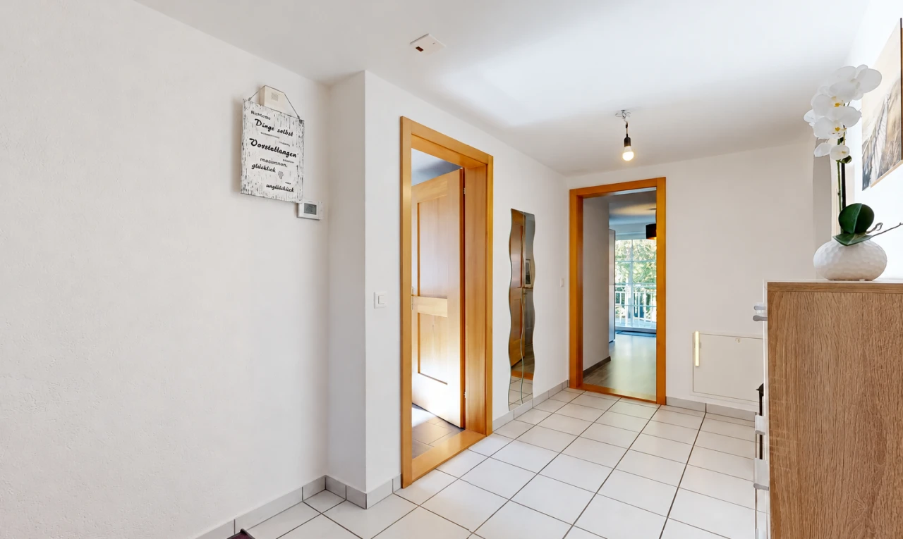 corridor featuring light tile patterned floors and baseboards