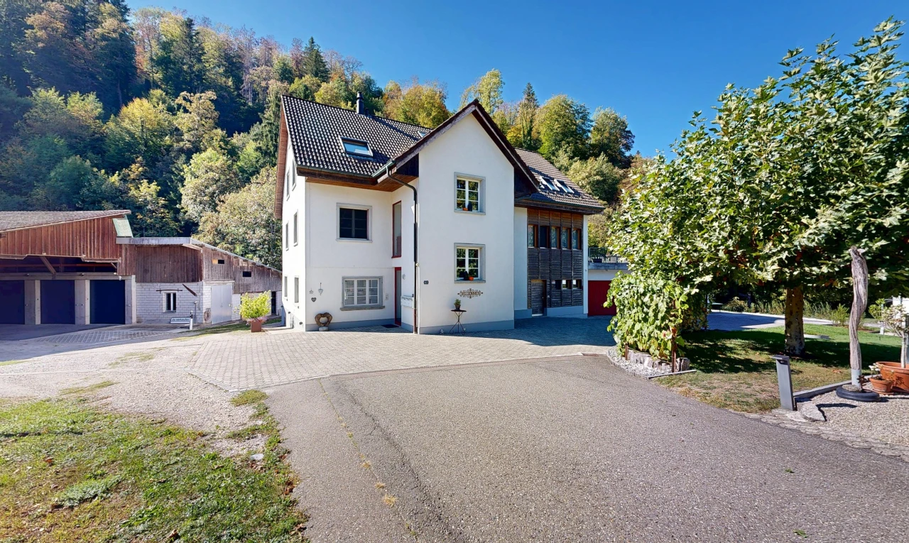 view of property featuring driveway, stucco siding, a tile roof, and a garage